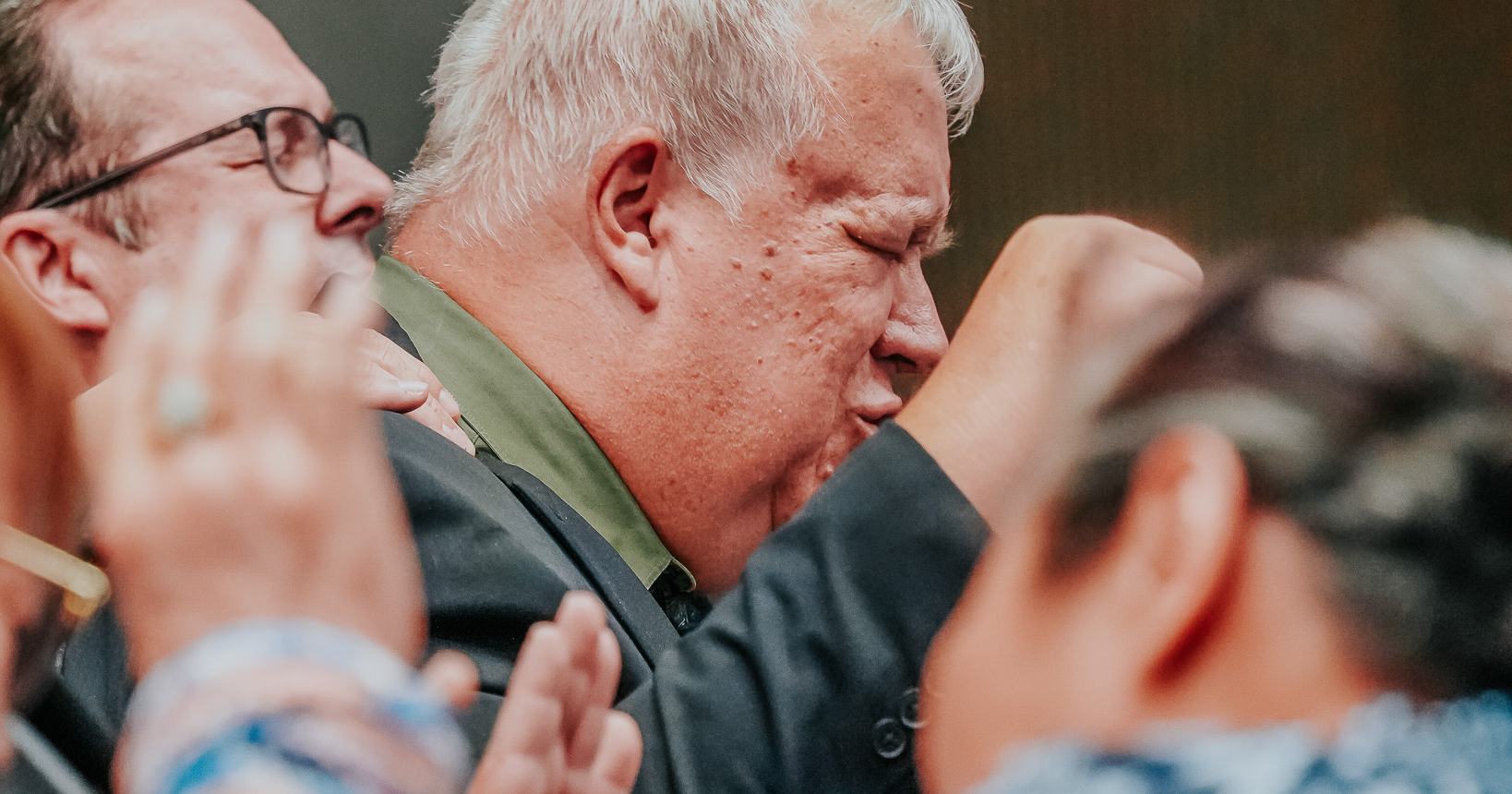 Men in heartfelt prayer and worship during a service at Praise Tabernacle Las Vegas