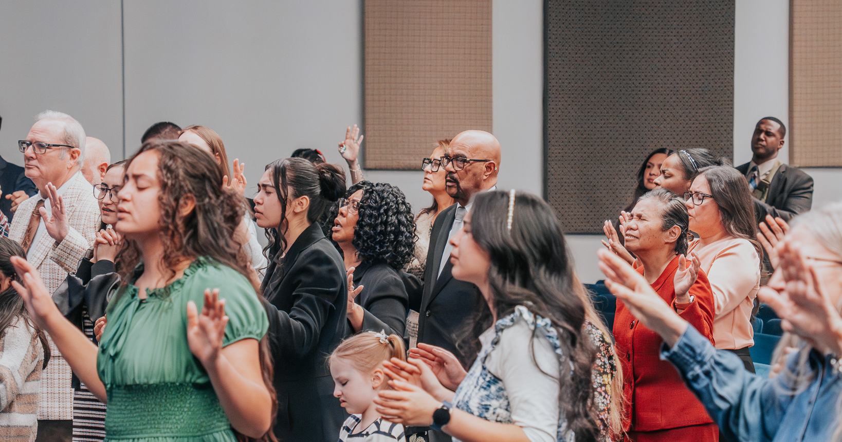 The Praise Tabernacle Las Vegas congregation standing with hands lifted in worship during a service